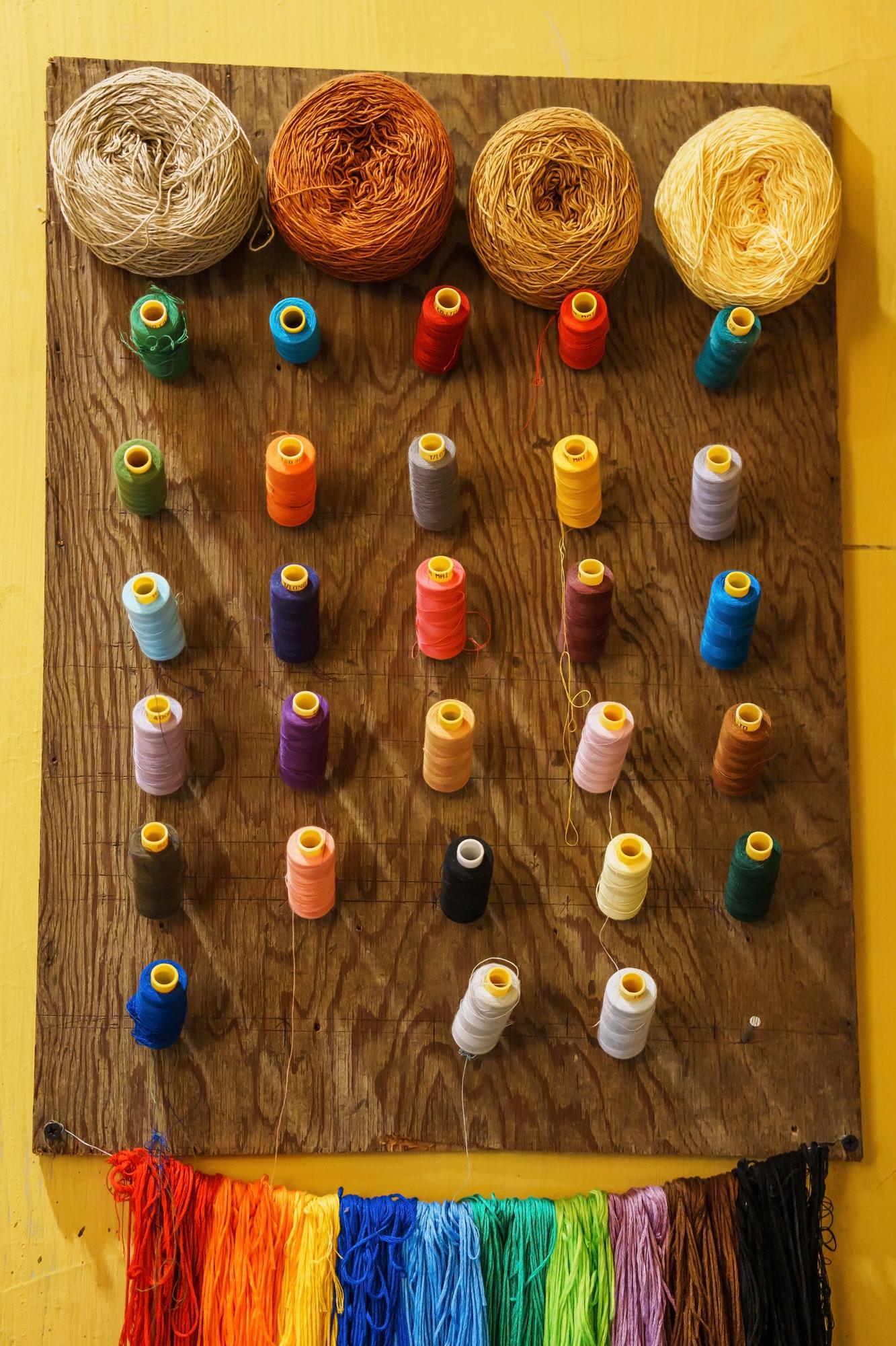 Gallery of embroidered patches and threads on a table