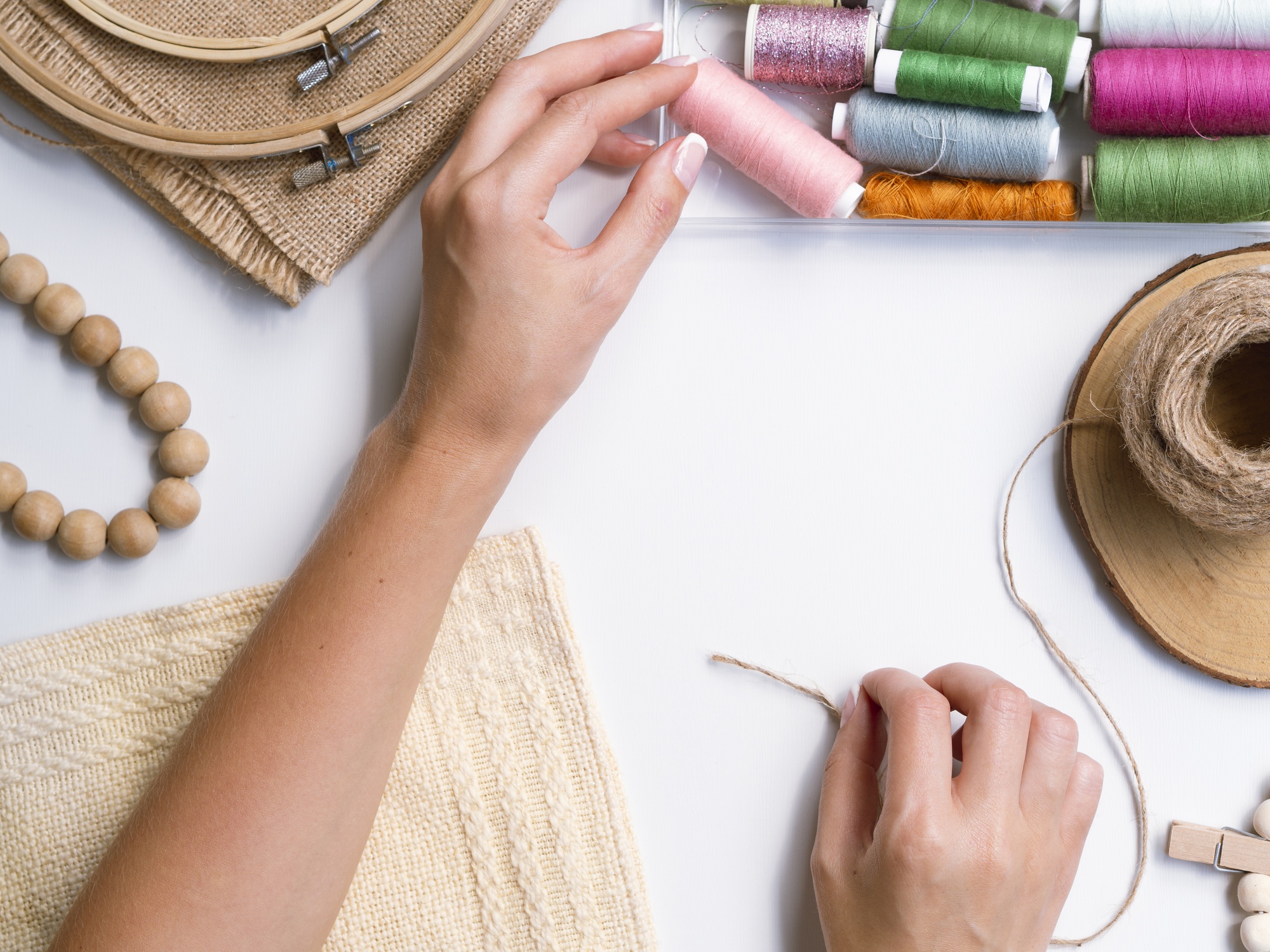 Worker stitching embroidery on a hoop in a small studio
